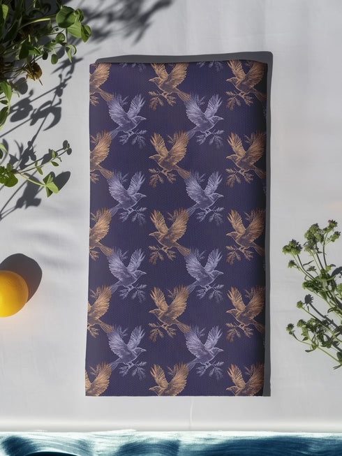Set of four slate blue dining napkins featuring alternating gold and silver ravens in flight with botanical accents, sized 18x18 inches.